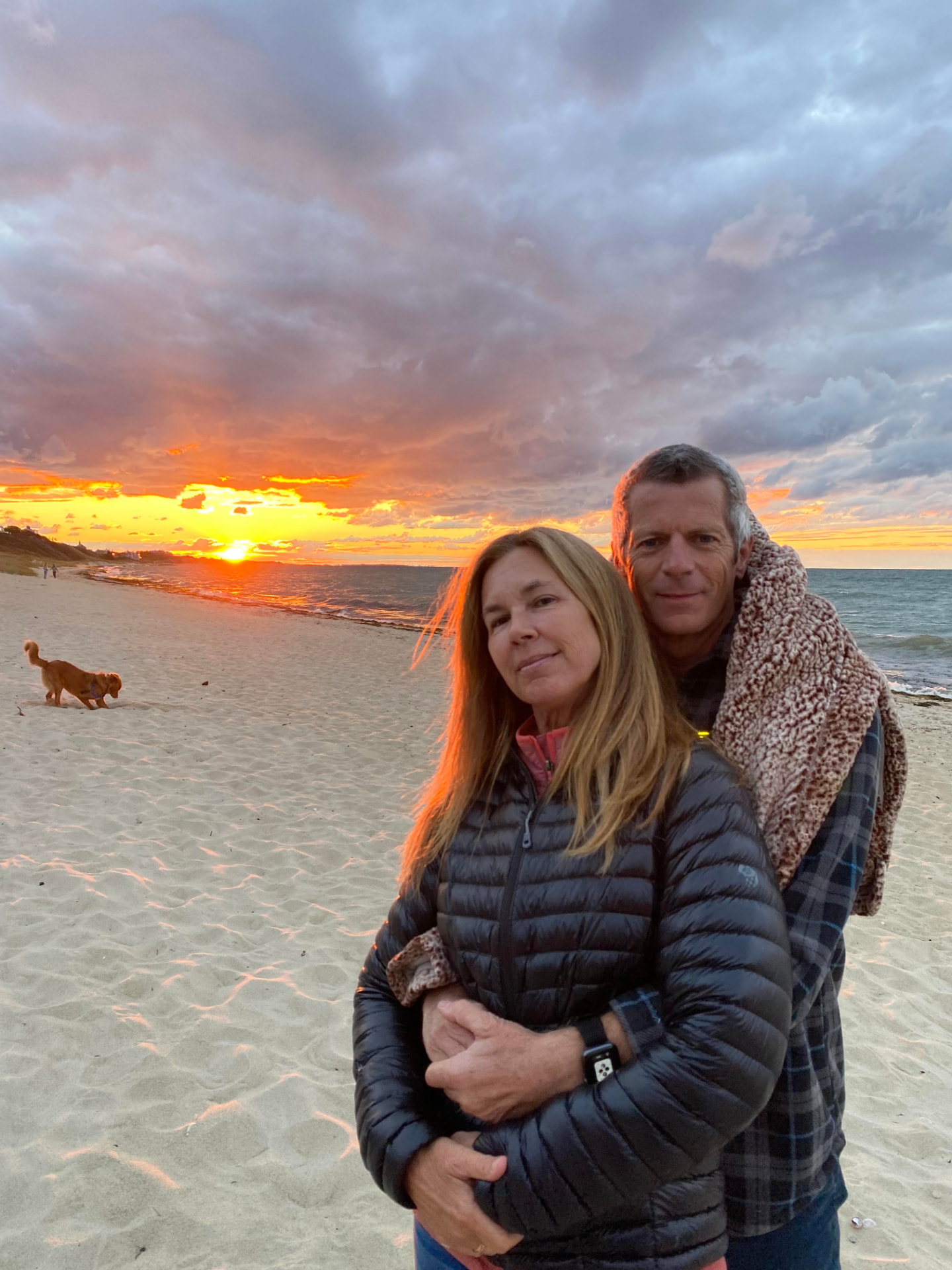 Marcy and Hunter on the beach at sunset with their dog